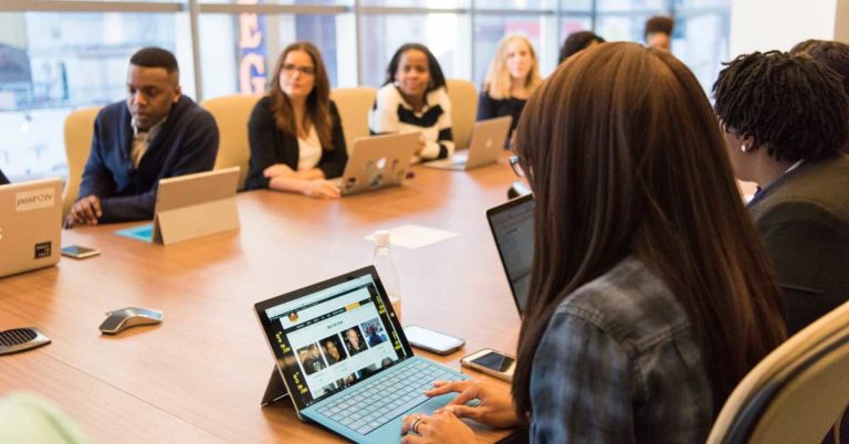 corporate meeting presentation with workers around a large conference table